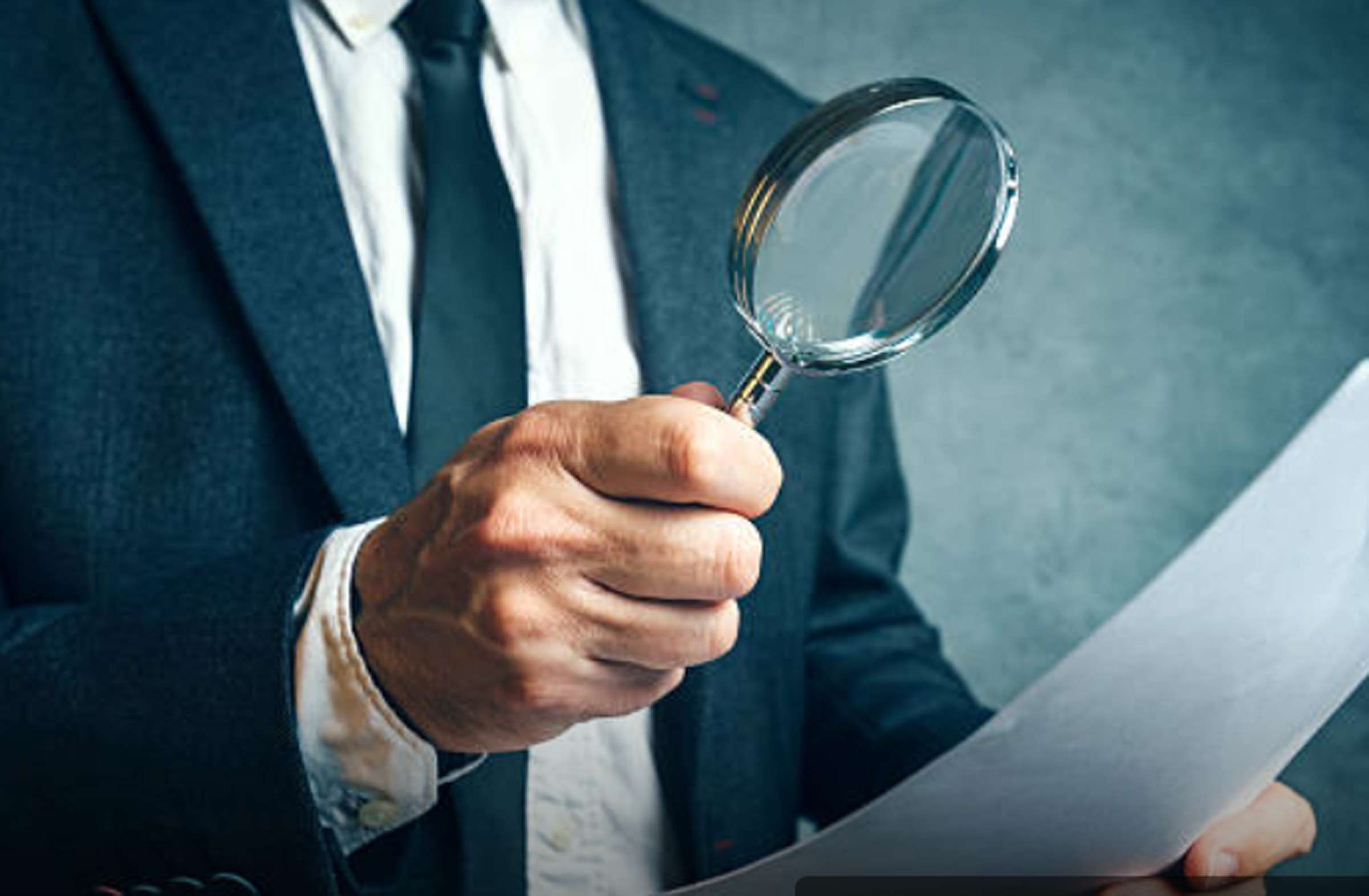 Man holding a magnifying glass fdoing DHET inspection